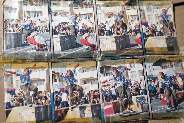 Series of eight color photographs of a skateboarder jumping over a cement block, one frame at a time.